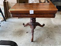 Full view of table closed showing rectangular burl wood veneer top and pedestal base.