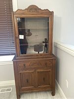 Three-quarter view of hutch showing glass display top and lower storage cabinet