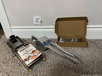View of the Palmer meat grinder, Mandoline slicer, and boxed cutlery set on floor