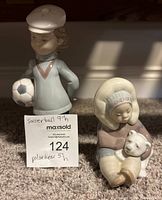 Photo showing two Lladro porcelain figurines: a 9-inch girl holding a soccer ball and a 5-inch girl holding a polar bear with maxsold label.