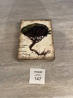 Photo of Sid Dickens Memory Block with tree design on a tiled surface.