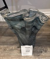 Front side view of the dark blue Murano glass vase with ruffled pinch top, showing swirling blue-gray glass pattern and organic flowing edges.