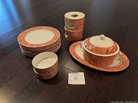 Full lot showing six dinner plates, covered serving dish with lid on platter, and two stacked bowls, all with rust marble-like Siena pattern