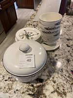 Photo showing 6 stacked bowls and 5 stacked side plates with floral design, covered dish with lid in front and 1 platter partially visible in back