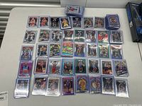 Overview of rectangular grid of approximately 40 basketball rookie cards from Panini Prizm and Donruss Optic placed on table
