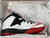 Right shoe in original box with tissue paper showing white, black and red colorway