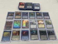 27 holographic Magic the Gathering Lord of the Rings special edition cards in protective sleeves laid out and stacked