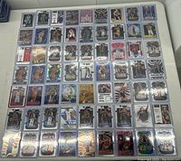 Full overview of approximately 60 basketball cards arranged in rows in protective sleeves on a white surface.