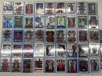 Wide view of multiple NBA basketball cards from the 2021 draft class and other years laid out in rows, showing a variety of player images and card designs including holographic backgrounds and action shots.