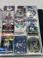 First photo showing 9 New York Giants NFL cards featuring multiple Saquon Barkley cards, Daniel Jones, and Eli Manning.