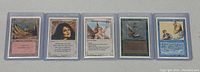 All five Magic the Gathering cards arranged side by side in protective cases