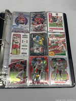 Photo of Patrick Mahomes football trading cards in protective binder sleeve showing diverse card designs and holographic effects