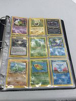 Image of nine Pokémon cards in a plastic sleeve, including Rattata, Seedot, Wigglytuff, Larvitar, and Wooper, showing front card artwork and text.