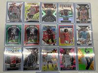 Front view of 16 soccer cards in protective sleeves featuring various players and teams from brands Mosaic, Topps, and Panini.