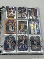 First page of binder with nine Stephen Curry basketball cards in protective sleeves, showing various action shots and designs.