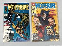 Front covers of Wolverine comic books issue #34 and #38, both in protective sleeves showing vibrant cover art and good condition.
