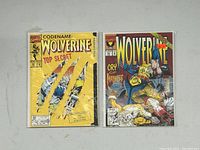 Two Wolverine comics, issue #50 with bright yellow cover and #51 with violent battle scene cover, both in protective sleeves with boards.