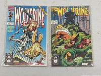 Two Wolverine comic books: issue 45 showing Wolverine battling with claws extended, and issue 47 showing Wolverine crouched in a jungle with another character above.