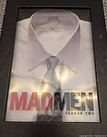 Front cover of the Mad Men Season Two DVD set showing a white dress shirt and tie graphic under plastic case.