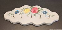 Full view of hand painted wooden key holder showing floral artwork and five brass hooks.