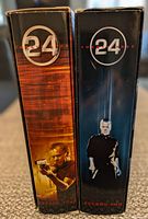 Side view showing spine of the two DVD boxed sets for season 2 and season 4 of "24." Season 2 box is dark blue with silhouette, season 4 is brown/orange with photo.