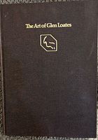 Front cover of The Art of Glen Loates book showing dark brown textured hardcover with gold embossed title and logo.