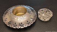 Flower frog holder separated from the glass insert showing engraved silver base with decorative cut-outs.