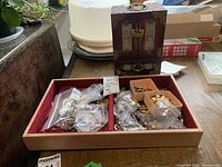 Top-down view of open wooden jewelry box filled with assorted jewelry pieces