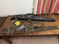 Two camouflage rifle carrying cases and a packaged shell holder laid on table showing brand logos, straps and patterns