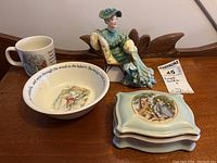 Full view of all items including the Royal Doulton Ascot figurine, Wedgwood Peter Rabbit cup and bowl, and hand-painted covered box.