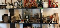 Full shelf displaying all collectible items including figurines, calendars, pin maze, clocks, bowls, and lantern