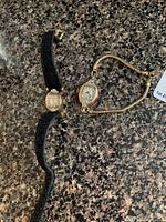 Overall view of two gold wrist watches on countertop