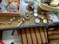 Overall assortment of watches on table, showing various wrist and pocket watches
