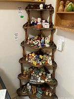 Full view of wooden corner shelf loaded with various small decorative items for scale and detail