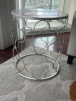 Full view of round side table showing marble top and decorative metal base.