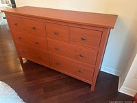 Front view of the IKEA chest of drawers showing 8 drawers, clean finish, and black knobs.