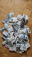 Overview photo showing a large assortment of button sets scattered on a wooden floor, multiple cards visible with buttons attached