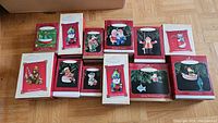 Twelve boxed Hallmark Keepsake ornaments with fishing themes arranged together showing box designs and variety of ornaments.
