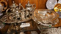 Overview of the mini silverplate tea set including teapot, sugar bowl, creamer, cups, and serving tray alongside decorative silver bowls.