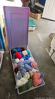 Photo showing the Rubbermaid storage bin with yarn inside, lid open.