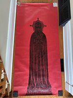 Photo of Sir John Lowe brass rubbing on red backing paper laid on the floor showing full length image of robed figure with headdress.