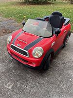 Front and side view showing details including headlights, racing stripes, and windshield.