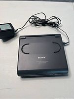Sony ICF-CD1000 clock radio closed, showing top and power adapter cable coiled beside it.
