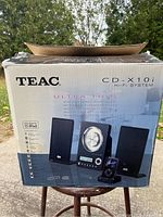 Front view of original box showing Teac Ultra Thin Hi-Fi System with speakers, central control unit, and iPod dock