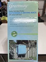 Front of the box with product name, brand Greenway, showing drying rack on balcony with towels hanging