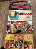 Top view of four Monopoly board games stacked, showing the Ford Mustang, Original, NFL Collector's Edition, and NHL Original Six