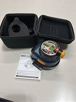 Ryobi laser level with carrying case and operator's manual on a light surface.
