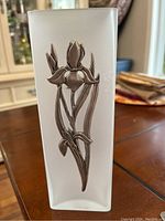 Close-up photo of the frosted square glass vase with etched surface and pewter Iris flower decoration