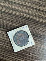 Front side of the 1850 Bank of Upper Canada token within a white protective holder showing detailed crest and text.