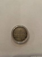 Front side of 1939 Canadian silver dollar showing the Parliament buildings and inscriptions.